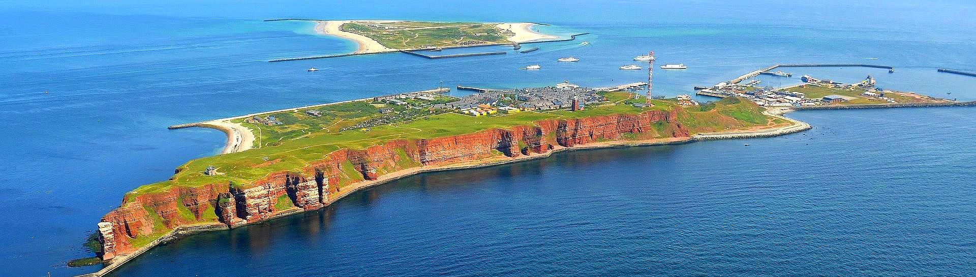 Luftaufnahme von Helgoland, mit Schiffen im Hintergrund.